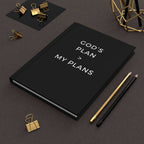 Black God's Plan Journal with white text and gold and black pencils on a leather surface with gold binder clips and geometric decor