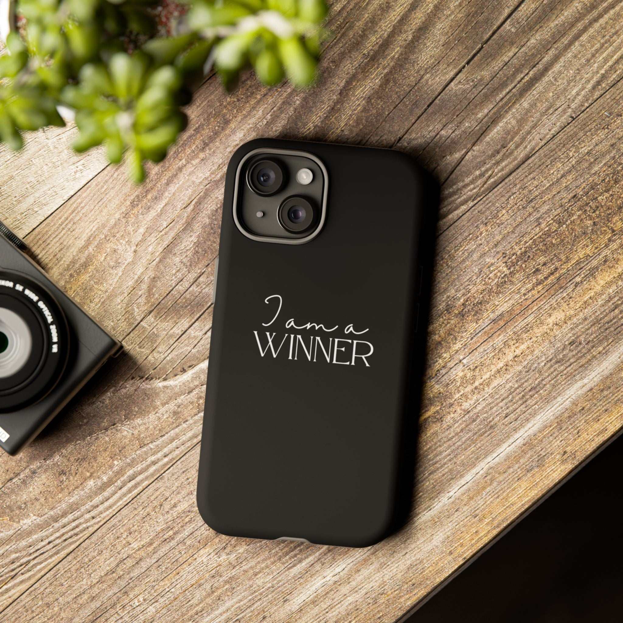 Black Winner Mindset phone case with "I am a WINNER" text, durable dual layer protection, matte finish, supports wireless charging