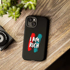 Black I Am Rich phone case with matte finish and bold text design on wooden surface