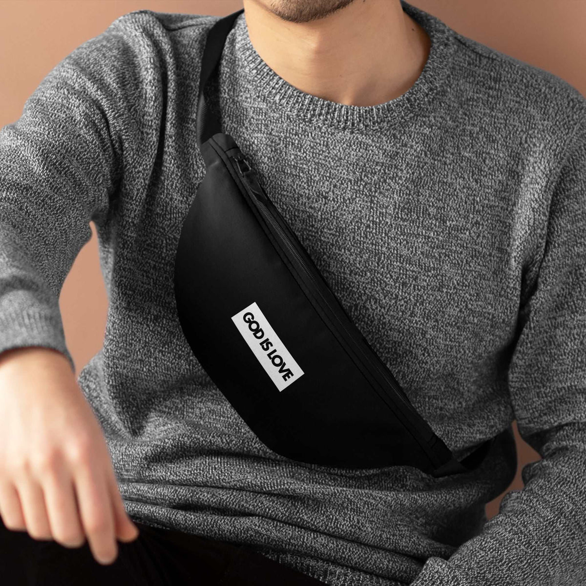 Black God Is Love fanny pack worn crossbody with one-sided print and zipper closure