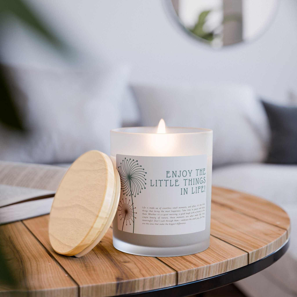 Lit glass candle with frosted vessel and maple lid on wooden table