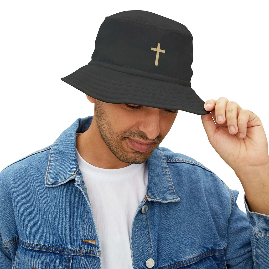 Man wearing black Faith Bucket Hat with gold cross symbol