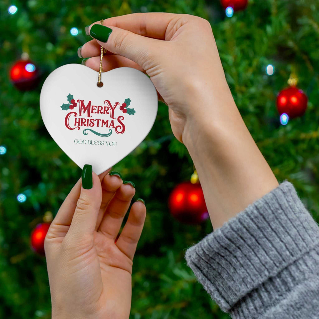 Merry Christmas ornament with gold string hanging on a Christmas tree