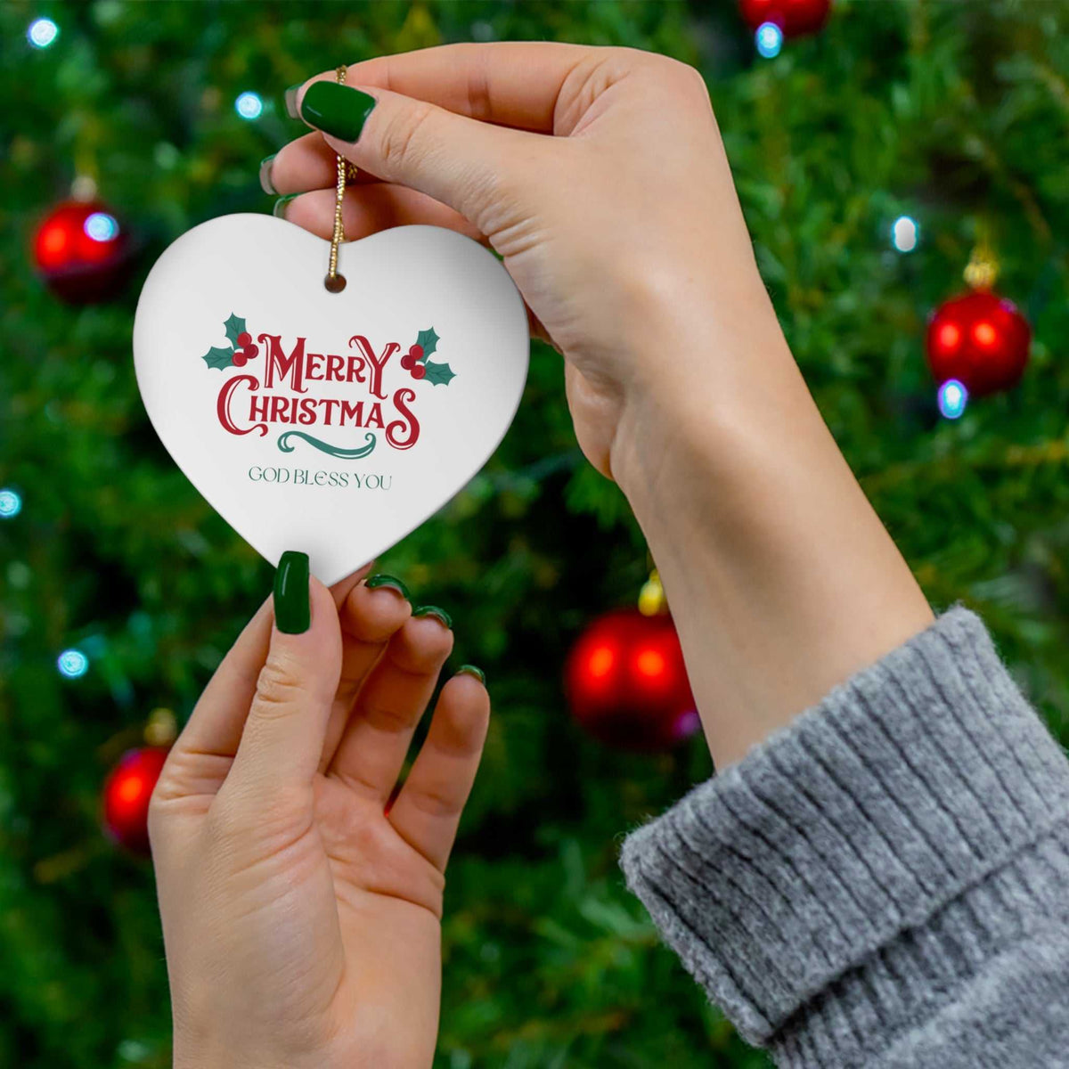 Merry Christmas ornament with gold string hanging on a Christmas tree