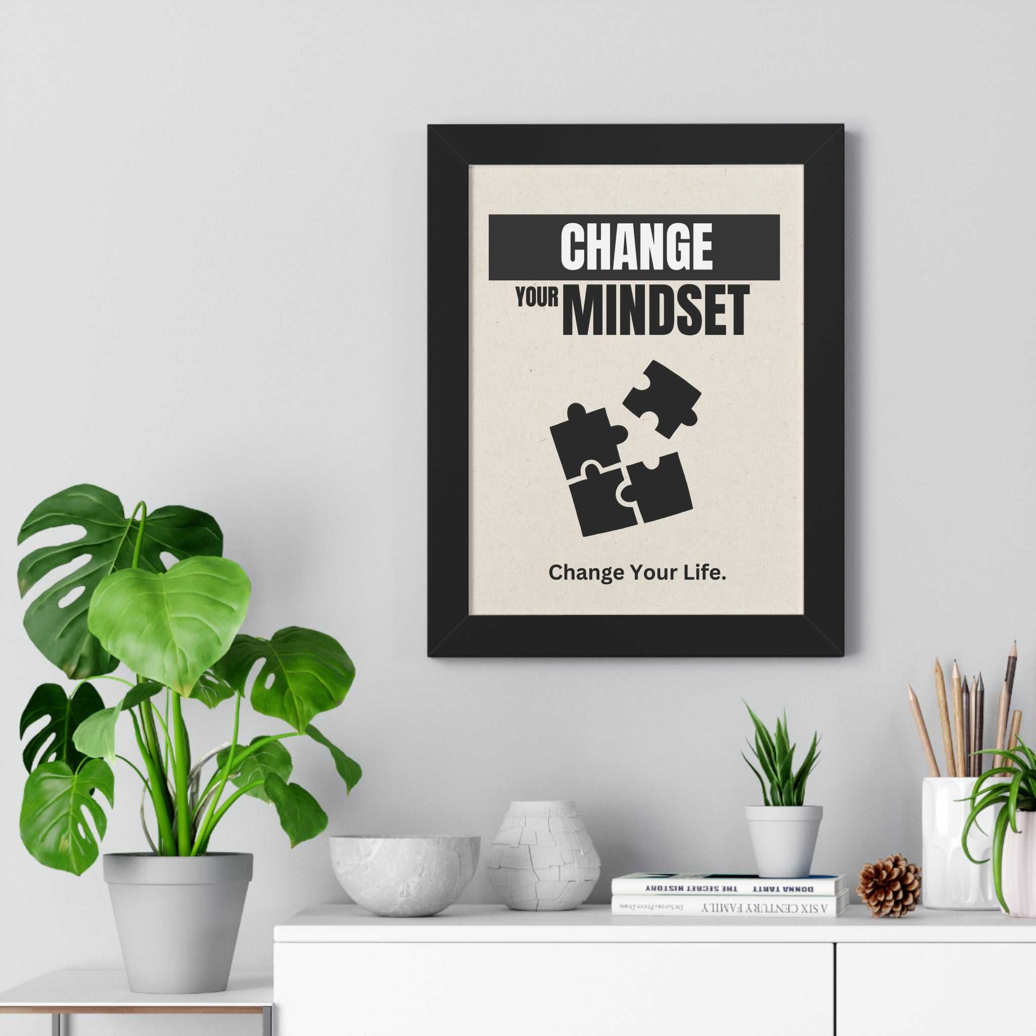 Framed New Mindset motivational poster with black Ayous wood frame on wall above white cabinet with plants and decor