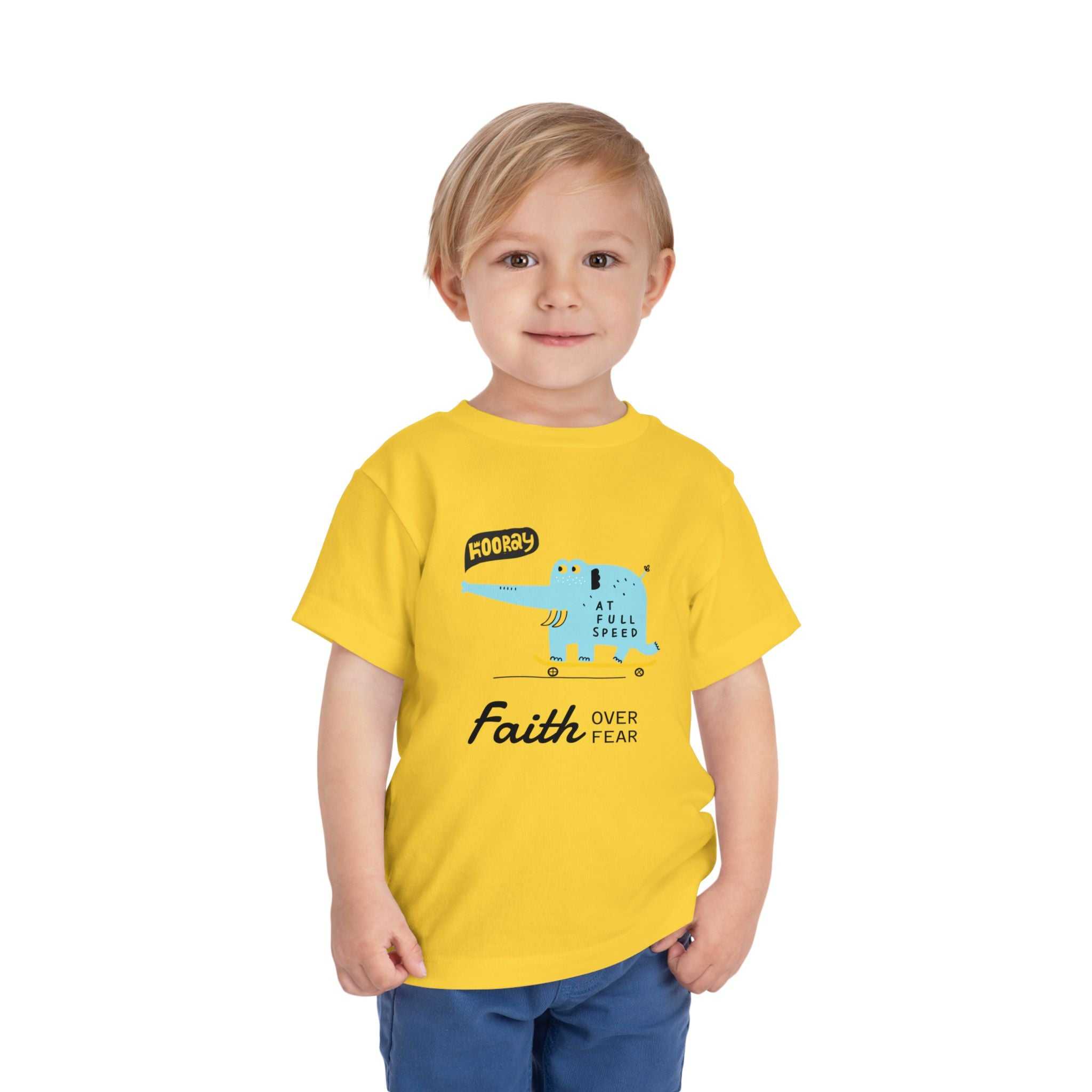 Toddler wearing yellow Faith Over Fear T-Shirt with blue graphic and inspirational text