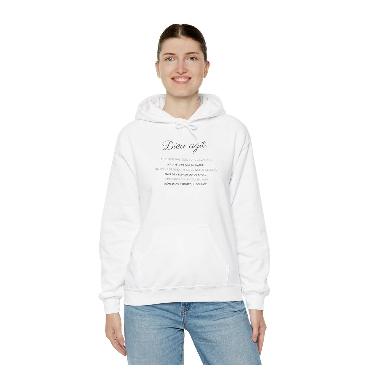 Woman wearing white Dieu En Action hoodie with faith-inspired text, classic fit hoodie for comfort and style