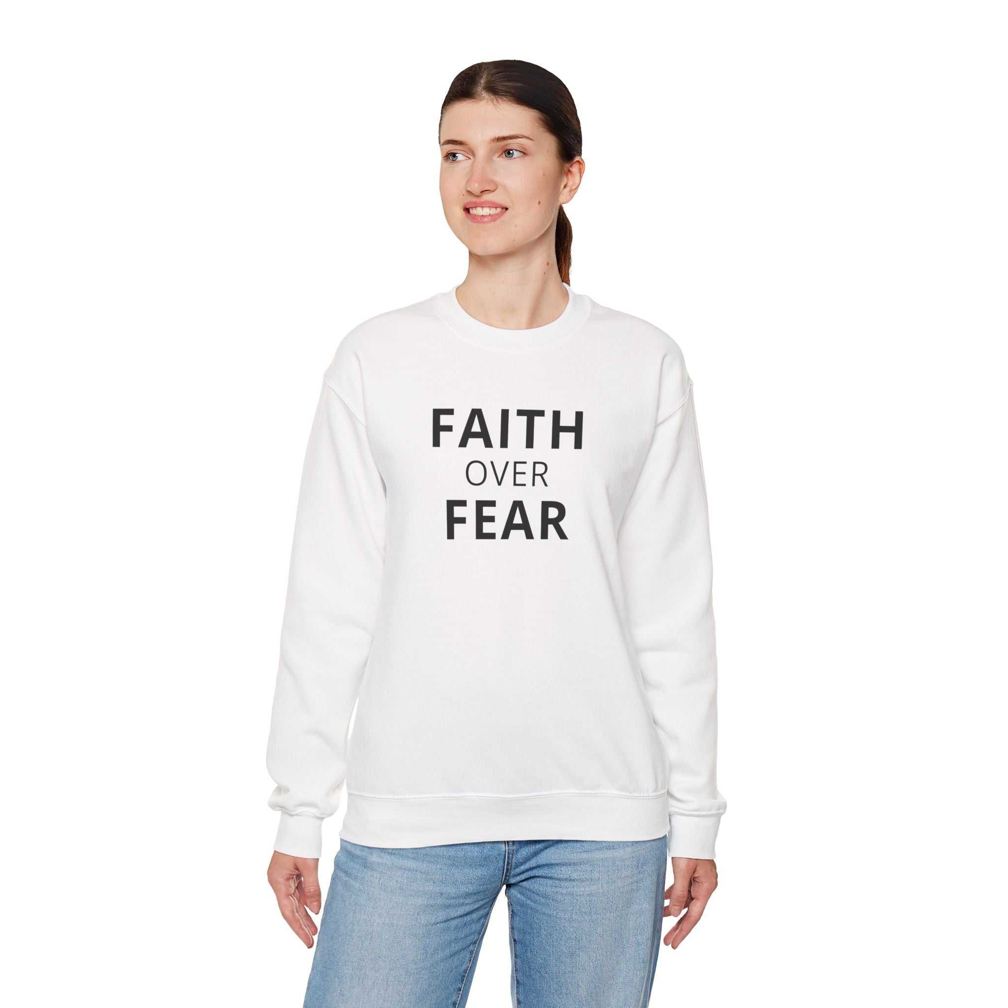 Woman wearing white Faith Over Fear sweatshirt with bold text, classic fit and comfortable blend of cotton and polyester