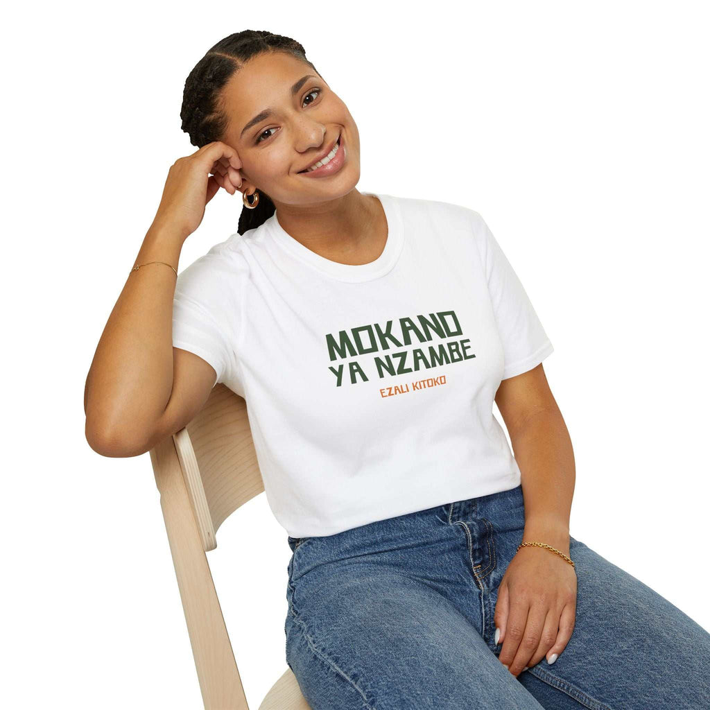Woman wearing white God's Plan T-shirt with Lingala phrase, paired with blue jeans, sitting on chair and smiling.