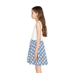 Young girl wearing smile sleeveless sundress with white top and blue daisy-patterned skirt side view